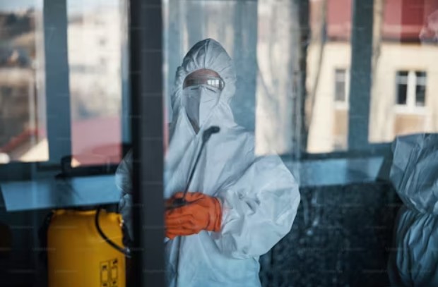 Asbestos removalist in full PPE performing an inspection, ensuring safe asbestos testing and removal services.